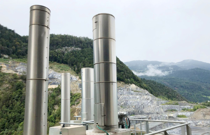several metal chimneys situated on a mountain summit